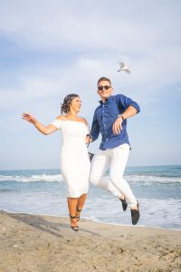 Un couple d'invité au mariage saute sur la plage de Sète