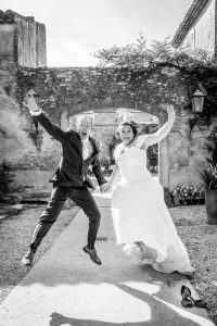 Couple de mariés sautant pendant la séance de photo de couple