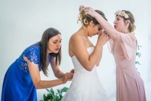 les demoiselles d'honneur aident la mariée à s'habiller