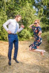 Un couple en habit de cocktail fait un saut dans un jardin