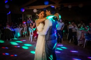 Mariage à Uzès, Les mariés dansent enlacés sous le regard de leurs invités et dans les éclairages colorés.